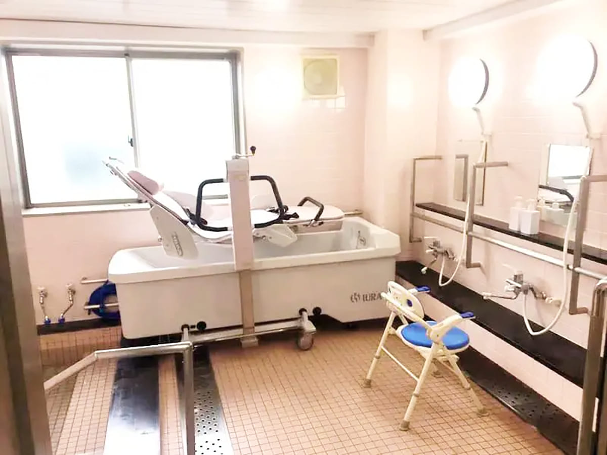 介護用の機械浴槽と入浴補助設備が整った浴室。安全手すり完備。